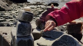 A child in Norway building a stone tower