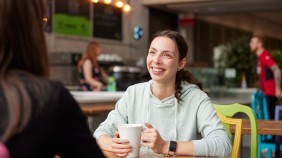 Student enjoying a coffee with a friend in a coffee shop