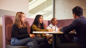 Four students sat around a table in the Business School